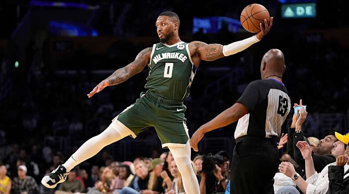 Bucks’ Damian Lillard saves the ball from going out of bounds in NBA preseason game vs. Lakers.